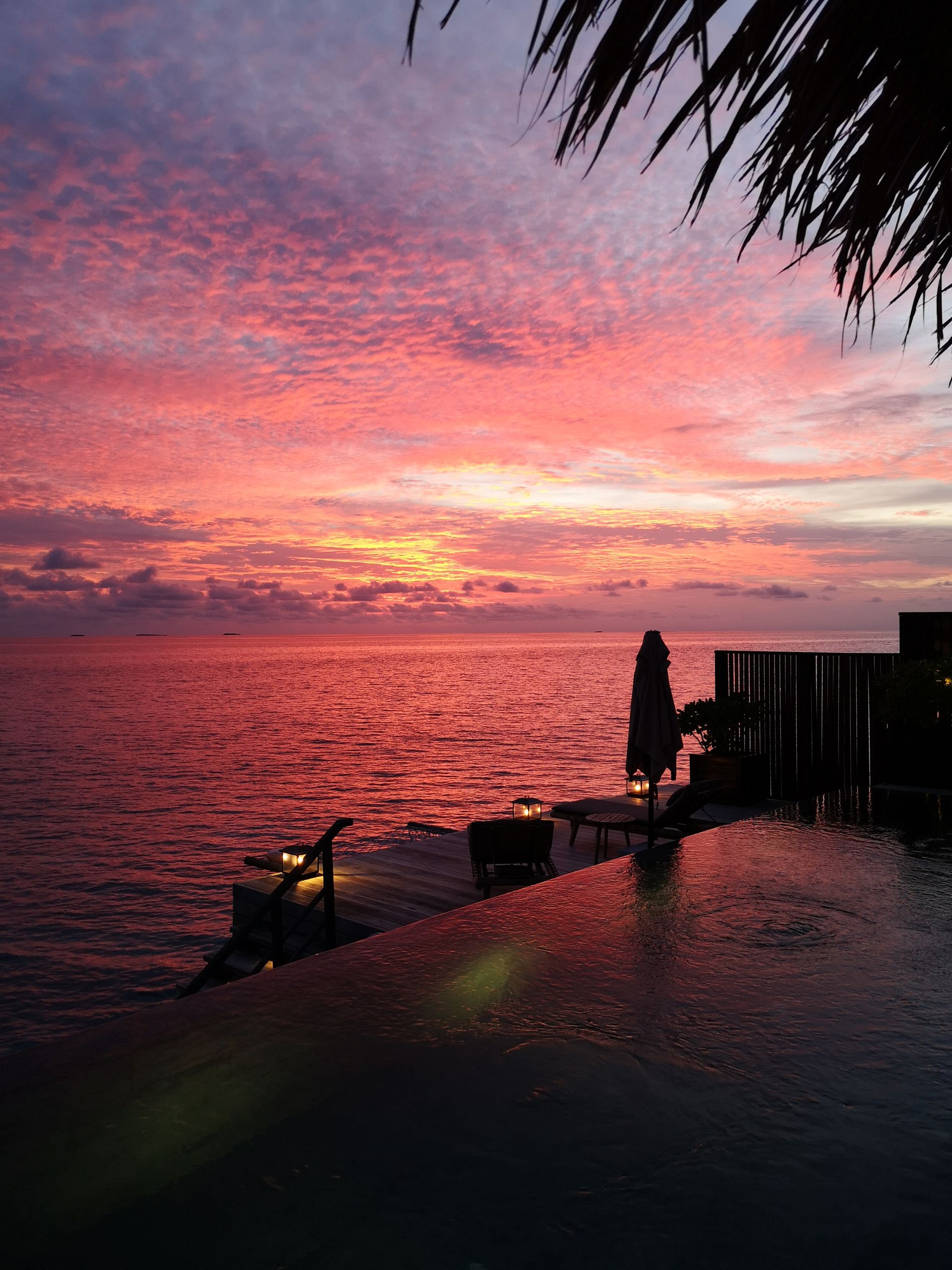 Resort infinity pool at sunset with lanterns
